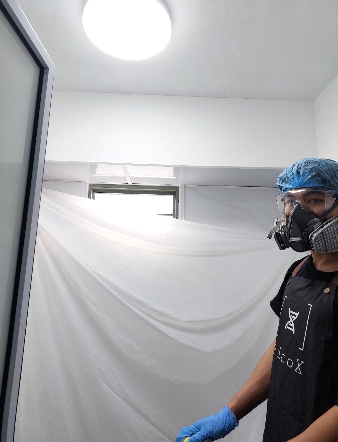 Pico X Health technician in full PPE including P100 respirator and safety goggles with containment sheeting - Singapore
